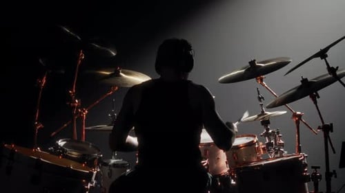 Cinematic Shot with Silhouette of Professional Rock Musician Playing Drum Kit Back View of Young