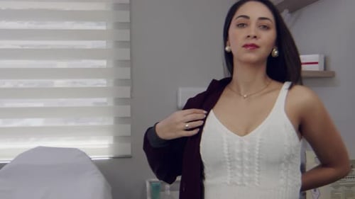 Female Hispanic doctor in her office putting her smock on for work - slow motion