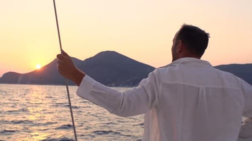 Young Man Admire Sunset While Sailing Boat on Sea Admire