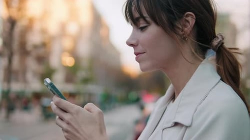 Smiling Woman Using Phone on City Street