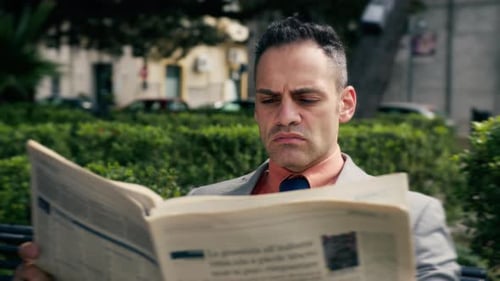 Geschäftsmann liest Zeitung im Freien