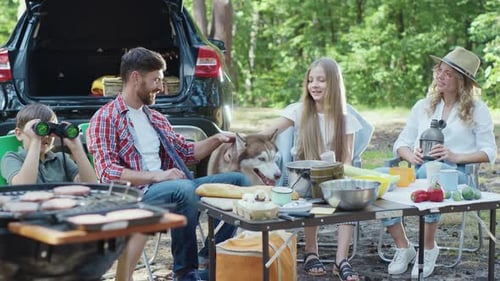 Family Picnic in Sunny Forest With Dog