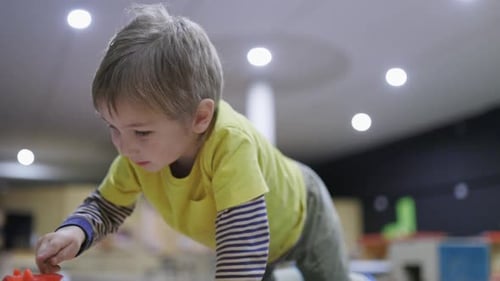 Curious Little Boy Playing with a Toy at the Playground