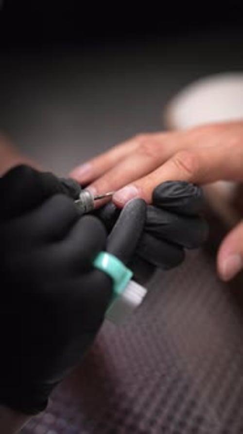 Manicurist Filing Nails with Electric Nail File