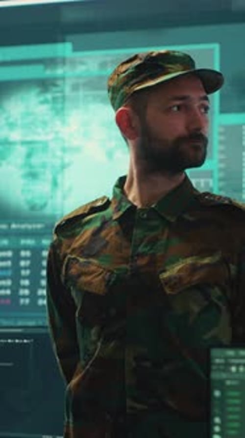 Soldier in Uniform Stands in Front of Screens
