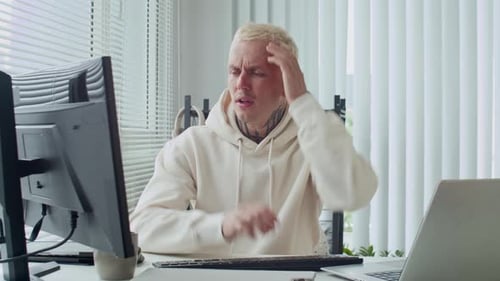 Besorgter Programmierer reagiert auf den Computerbildschirm im Büro