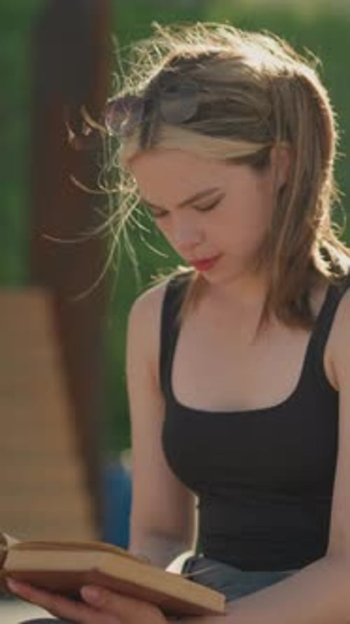 Young Woman Reading a Book in Sunlight