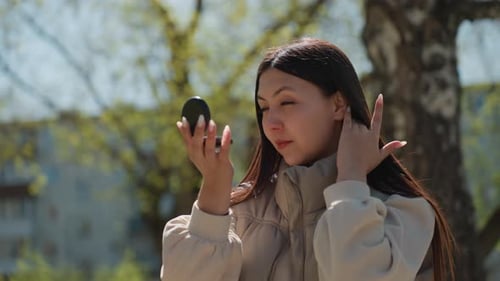 Closeup Portrait of Woman Checking Reflection and Posing Confidently Direct Gaze and Soft Sunlight