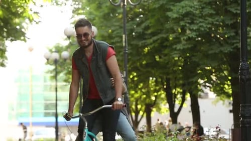 Jovem casal andando de bicicleta juntos no parque Namorado romântico andando de bicicleta com namorada feliz