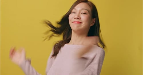 Cheerful Woman Smiles Against Yellow Backdrop