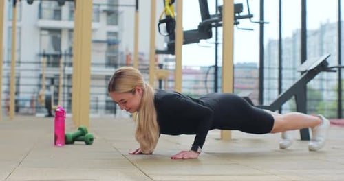 Blonde Woman Doing Pushups in Outdoor Gym