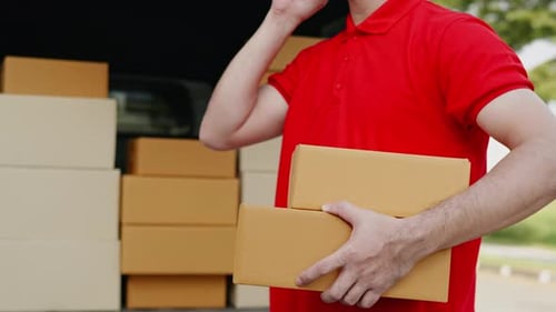 Delivery man, driver calling to customerr for sending parcel box package in the cargo truck at home