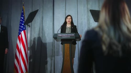Woman Speaks at Press Conference with Flags