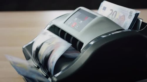 Money Cash Counting By Electronic Calculation Machine Standing On Table Close Up. Man Hand Puttin...