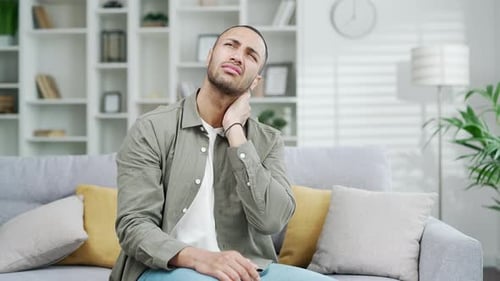 Young Man Rubbing Neck with Neck Pain