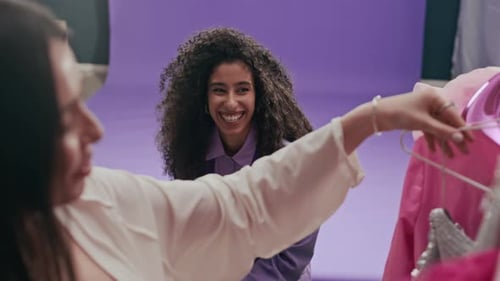 Two Women in Fashion Studio with Pink Clothing