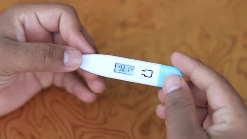 Digital thermometer. Reading body temperature from a thermometer closeup