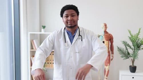 General Practitioner in White Coat Posing in Doctor's Office