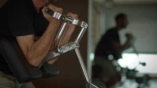 Man on Bicep Curl Machine at Gym