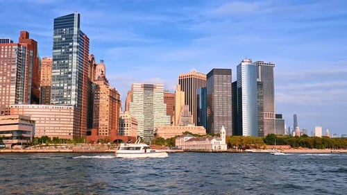Boats move along the waterfront of New York on sunny day.