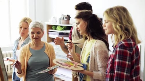 Group learns painting class inside sunny studio