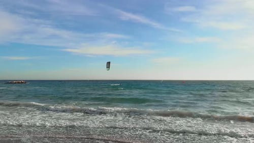 Aktive Menschen, die an einem sonnigen, windigen Tag auf den Wellen Kitesurfen und Windsurfen