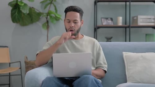 Young Adult Man Works on Laptop at Home
