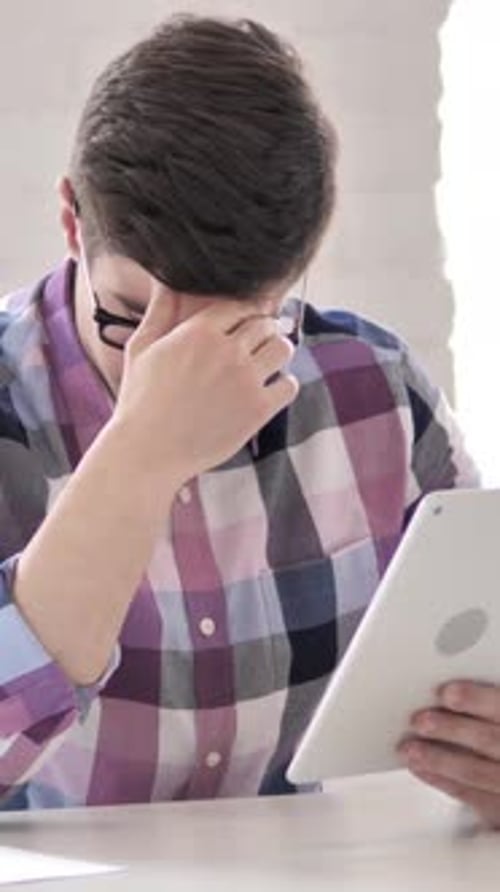 Young Man Using Tablet in Bright Room