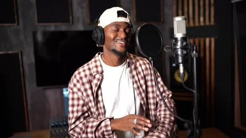 Young african american singer recording music in professional studio