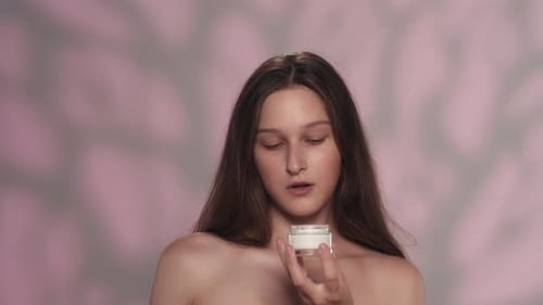 Young Woman Applying Cream to Face
