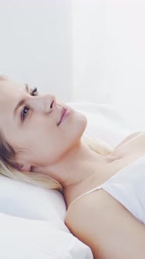 Woman Sleeping Peacefully in Bed in a Bright Room