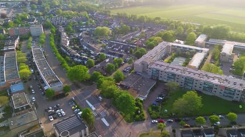 Aerial view of a suburban neighborhood with townhouses, apartment blocks, tree-lined roads