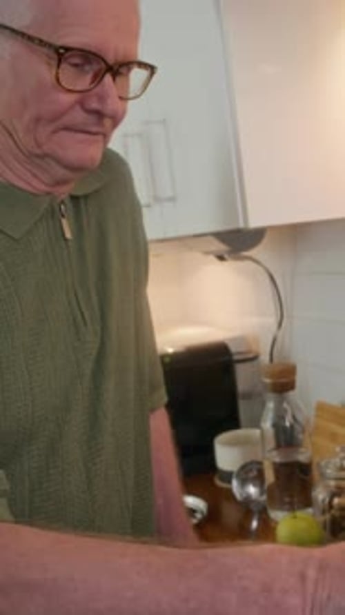 Senior Man Cooking in Kitchen with Mature Woman