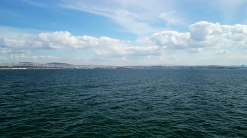 Aerial footage over the ocean by the coast in the summertime, low altitude