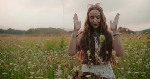 Woman Meditating in a Wildflower Meadow at Sunset
