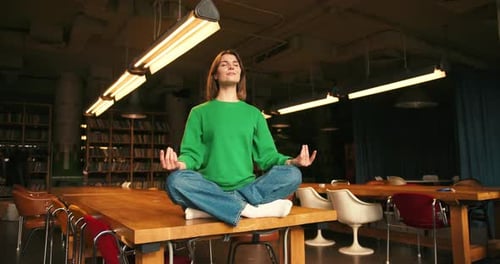 Woman Sitting Cross Legged on Table Meditating