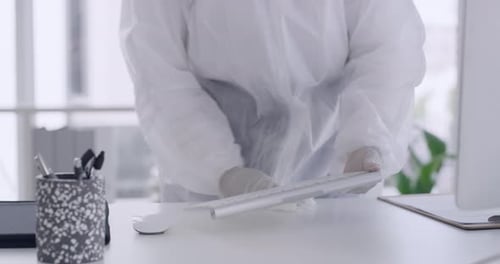 Healthcare worker sanitizing office with antibacterial wipes for protection against coronavirus