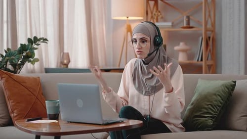 Junge Araberin spricht zu Hause per Videoanruf per Laptop