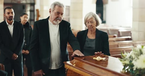 Funeral, church and couple with hand on coffin for goodbye, mourning and grief in memorial service