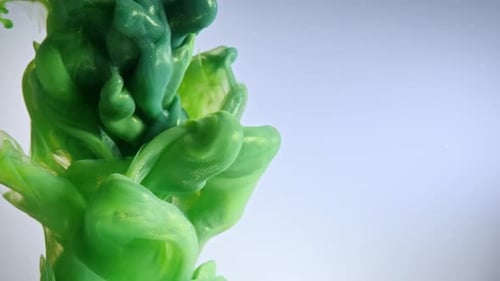Swirling Green Ink on Light Blue Background