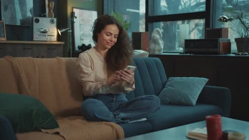 Woman Smiling and Laughing Using a Mobile Phone