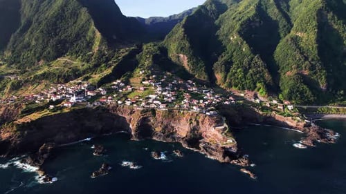 Aerial view of a city on a rocky volcanic green coast, Seixal, Madeira