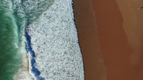 Luftaufnahme des tropischen Strandes, Blick von oben auf den Wellenbruch am tropischen gelben Sandstrand. Nahtlose Meereswellen