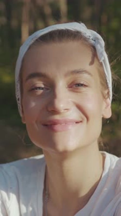 Joyful Woman Enjoying the Outdoors Wearing a Headband and Smiling Brightly Amidst Nature