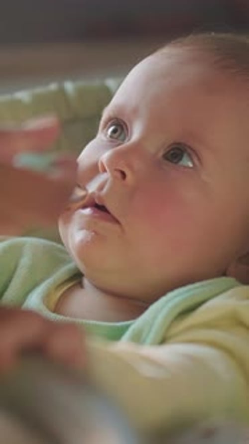 Adorable Infant Being Spoon Fed Food Indoors