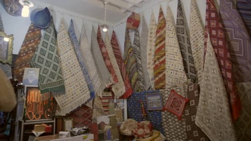 Colorful Carpet, Rugs, And Textile Shop On Stall Market In Tunis Medina, Tunisia. Pan Right