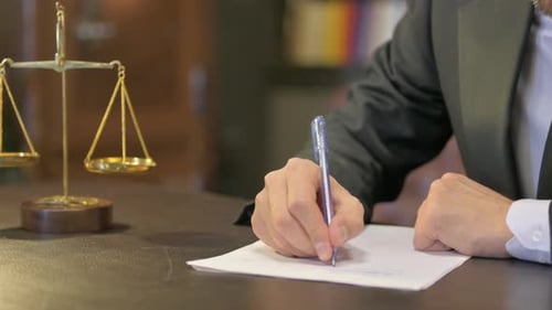 Close up of Male Judge Writing Verdict in Office