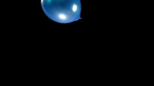 Blue Balloon Ascending Slowly on Black Background