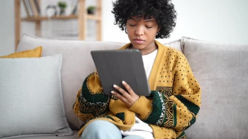 Woman Uses Tablet on Sofa at Home