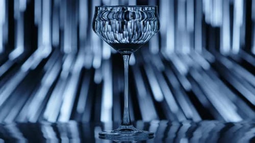 Copo de vinho transparente em frente a uma chuva caindo, como um padrão no fundo
